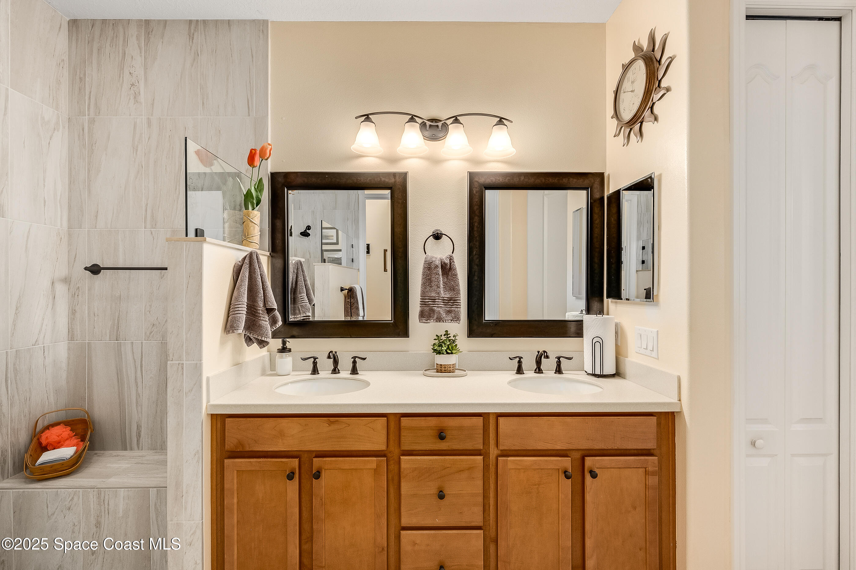 5738 Tamarac Drive Melbourne, FL 32940 - Photo 15 of 27 a bathroom with double vanity sinks and a mirror