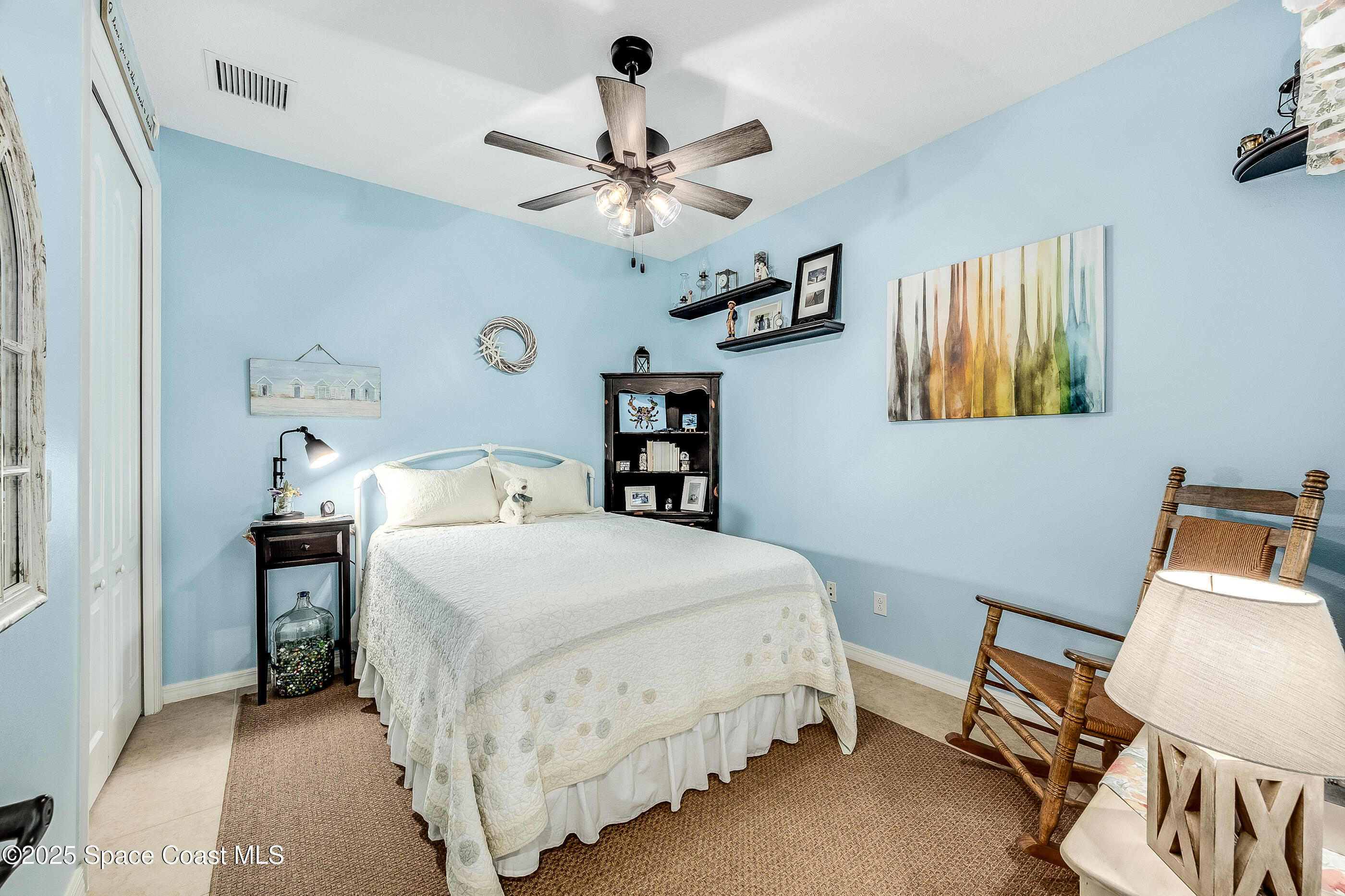 5738 Tamarac Drive Melbourne, FL 32940 - Photo 17 of 27 a bedroom with a bed and a chandelier