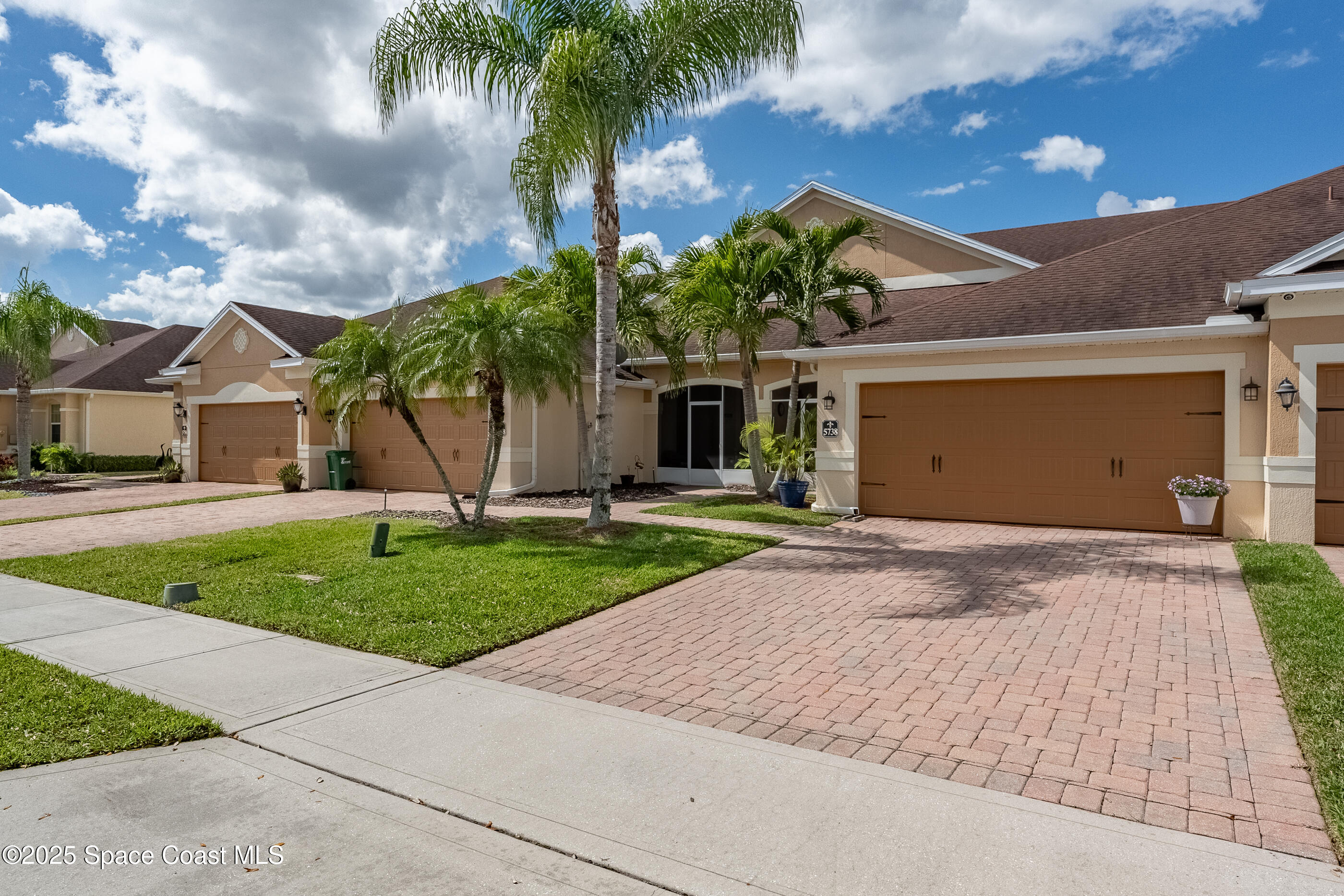 5738 Tamarac Drive Melbourne, FL 32940 - Photo 2 of 27 a front view of a house with a yard and garage