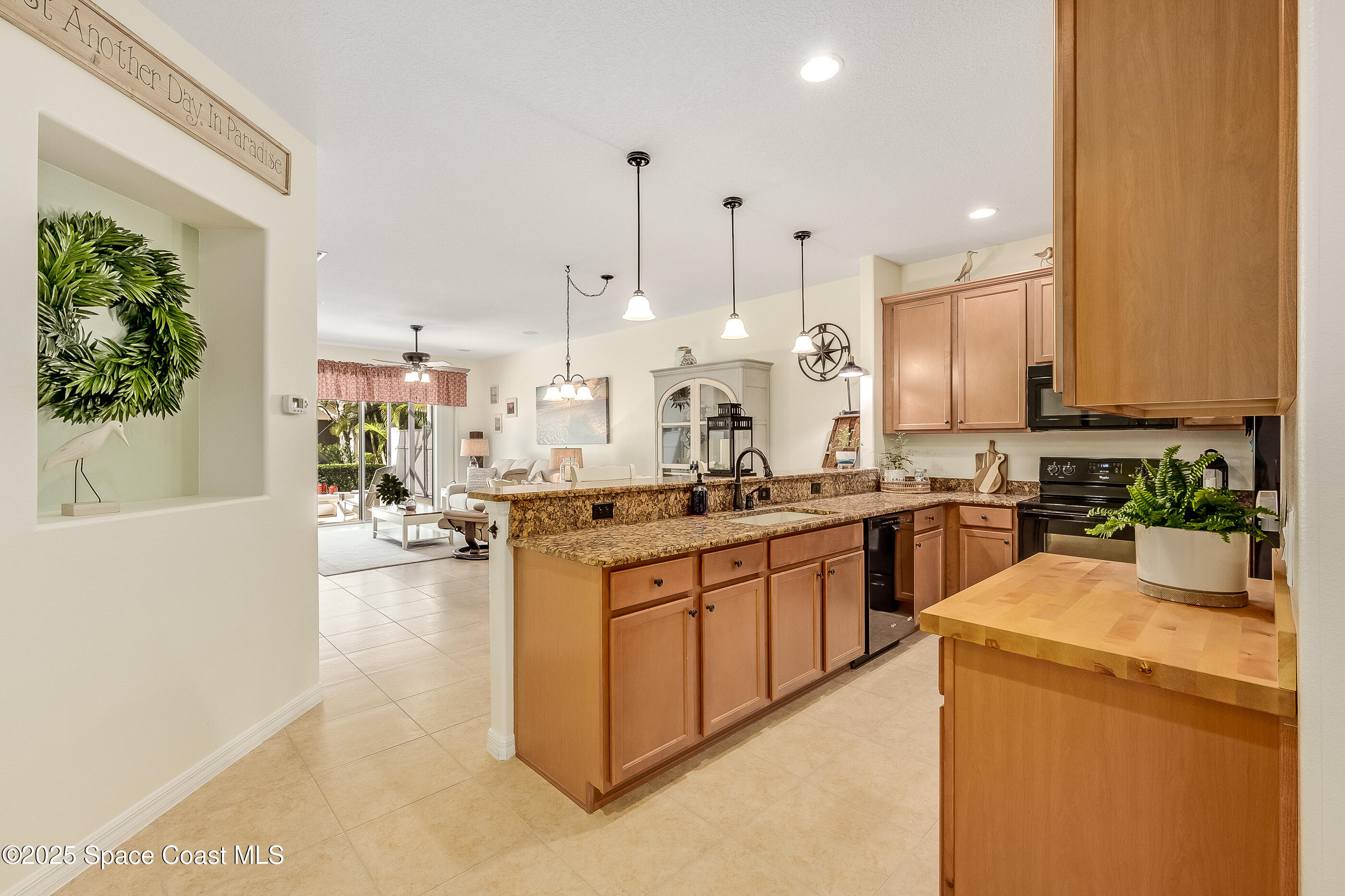 5738 Tamarac Drive Melbourne, FL 32940 - Photo 7 of 27 a large kitchen with kitchen island a large counter top space a sink stainless steel appliances and cabinets
