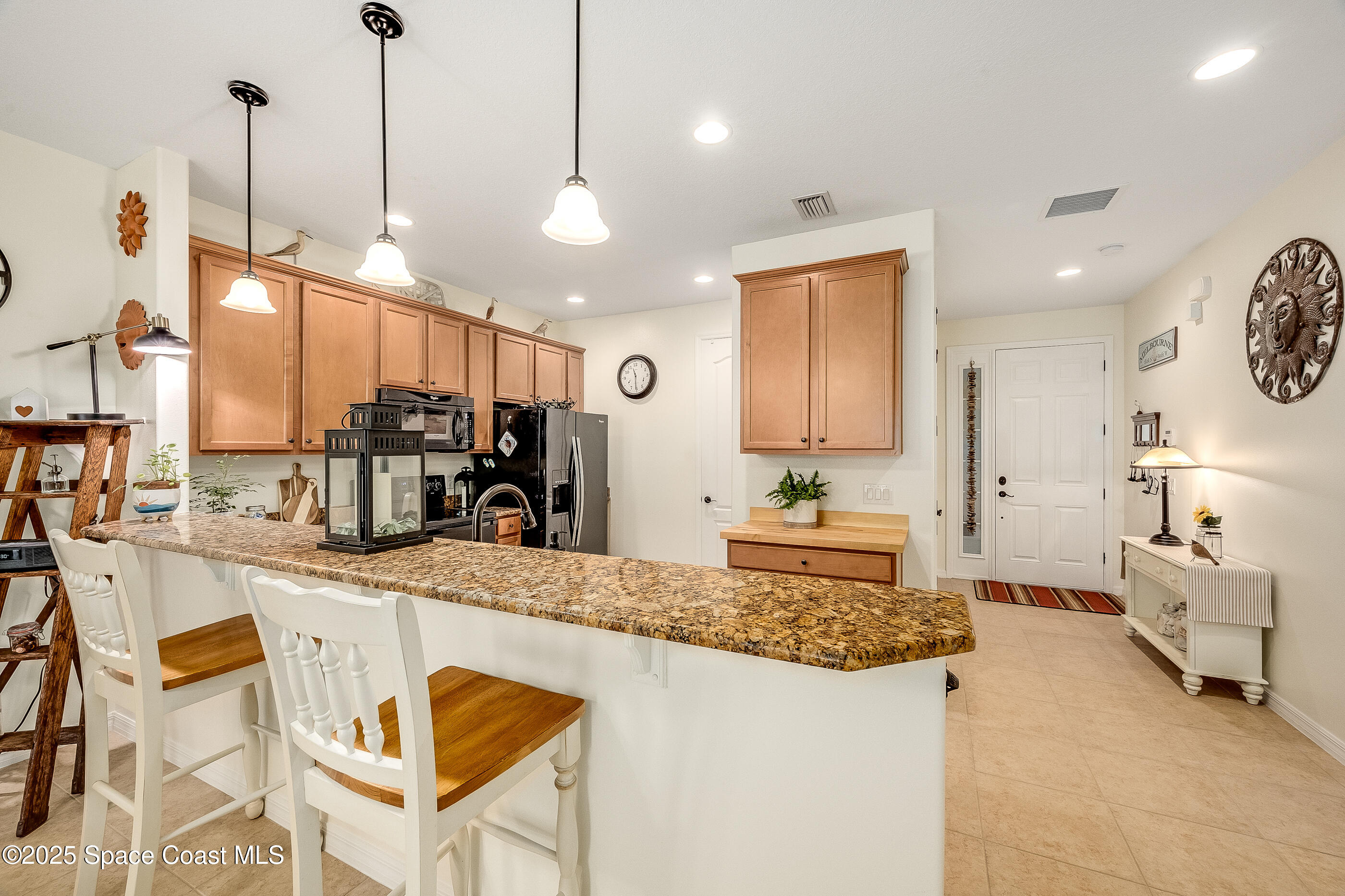 5738 Tamarac Drive Melbourne, FL 32940 - Photo 8 of 27 a large kitchen with kitchen island a large counter top space a sink stainless steel appliances and cabinets