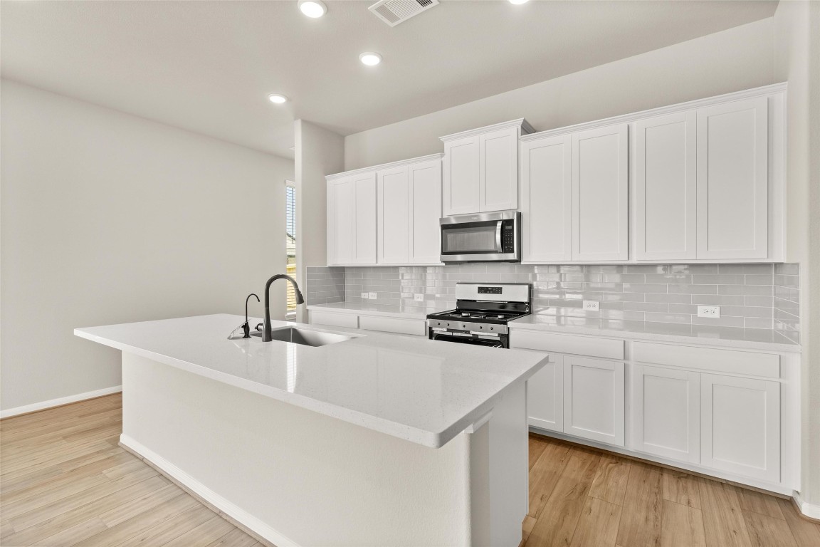 313 Redbud Rdg Drive Brookshire, TX 77423 - Photo 6 of 32 a kitchen with sink a microwave and cabinets
