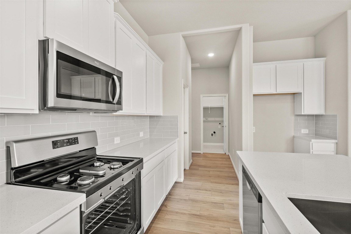 313 Redbud Rdg Drive Brookshire, TX 77423 - Photo 7 of 32 a kitchen with stainless steel appliances granite countertop a stove and a microwave