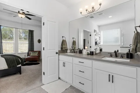 a spacious en suite bathroom with double sink and a mirror