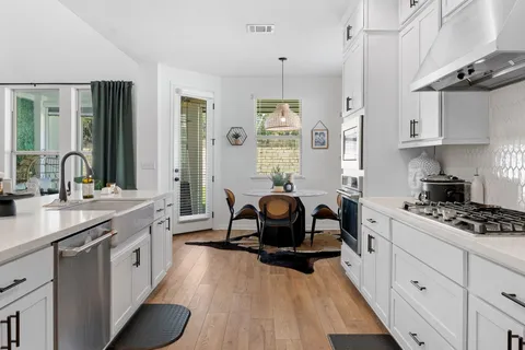 a kitchen with a sink stove and cabinets