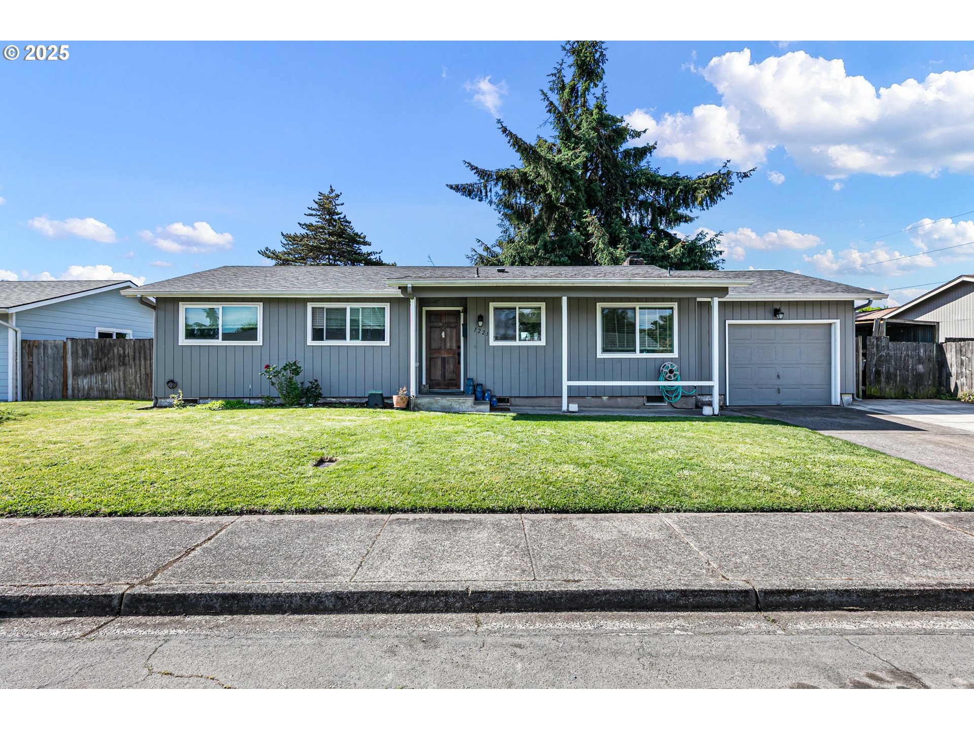 1221 Kenray Loop Springfield, OR 97477 - Photo 1 of 19 a front view of a house with a garden and yard