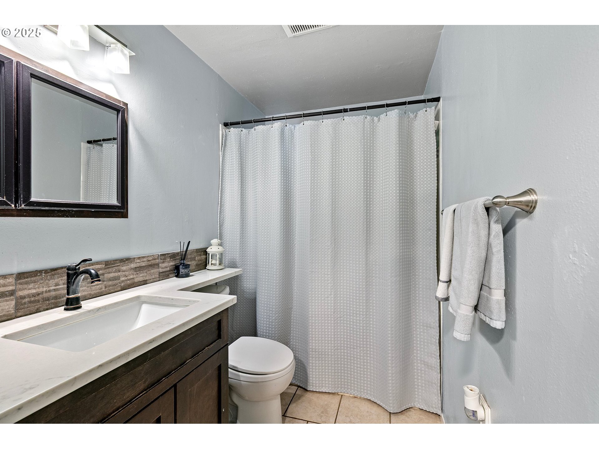 1221 Kenray Loop Springfield, OR 97477 - Photo 11 of 19 a bathroom with a sink a toilet a mirror and shower curtain