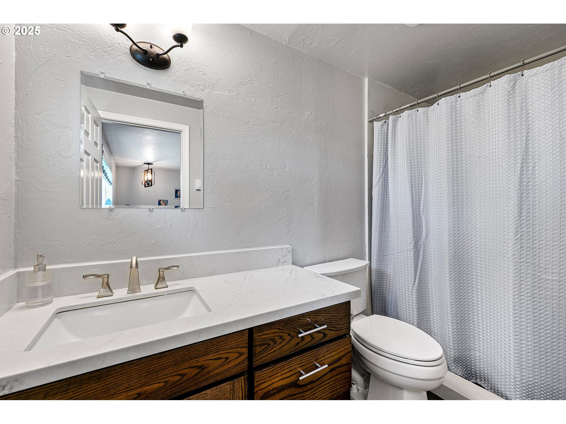 1221 Kenray Loop Springfield, OR 97477 - Photo 16 of 19 a bathroom with a sink a toilet a mirror and shower curtain