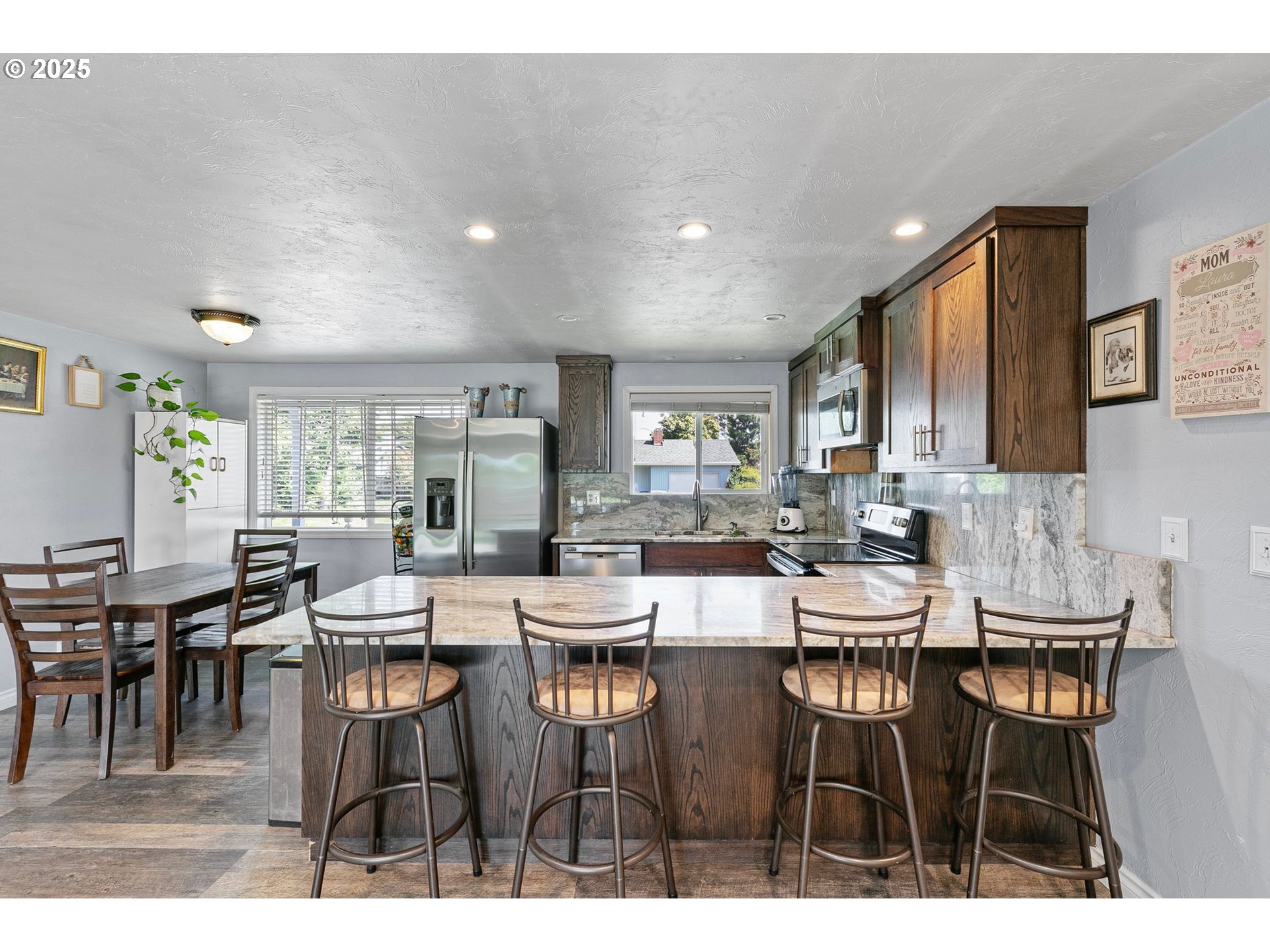 1221 Kenray Loop Springfield, OR 97477 - Photo 5 of 19 a dining hall with stainless steel appliances kitchen island granite countertop a dining table chairs and view living room