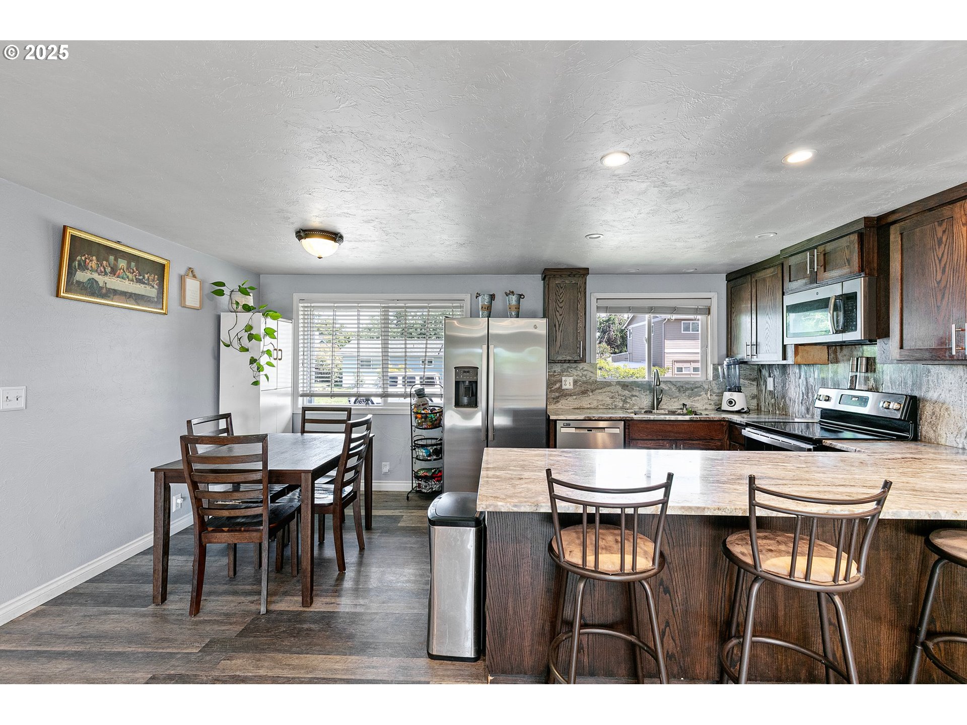 1221 Kenray Loop Springfield, OR 97477 - Photo 7 of 19 a dining hall with stainless steel appliances kitchen island granite countertop a dining table chairs and granite counter tops