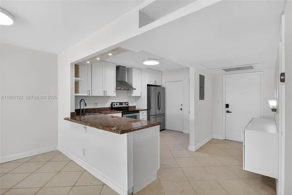 a kitchen with stainless steel appliances granite countertop a sink and a refrigerator