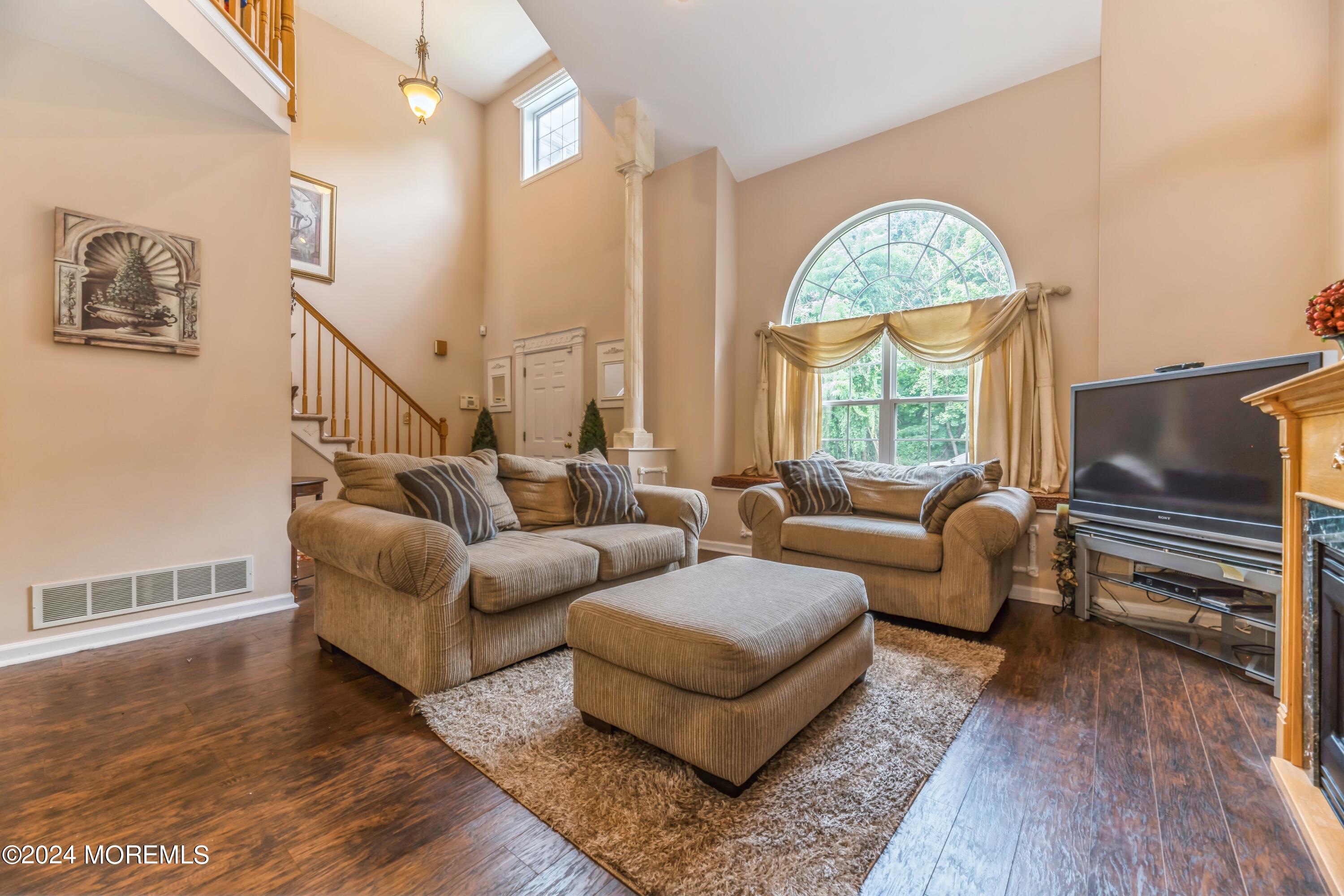 95 Nutmeg Road Aberdeen, NJ 07747 - Photo 3 of 21 a living room with couches a coffee table and a large window with wooden floor