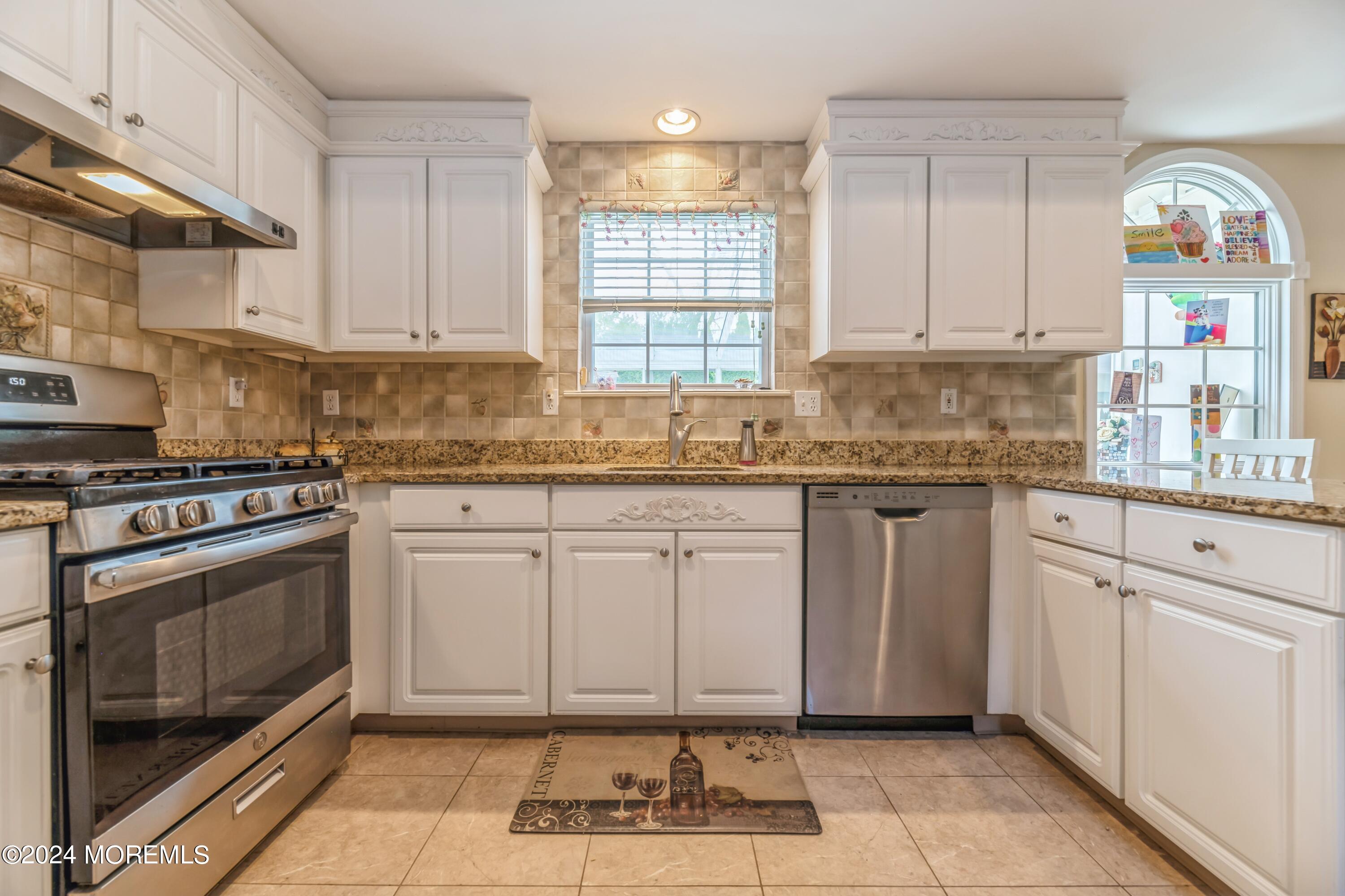 95 Nutmeg Road Aberdeen, NJ 07747 - Photo 5 of 21 a kitchen with granite countertop a stove a sink and a microwave