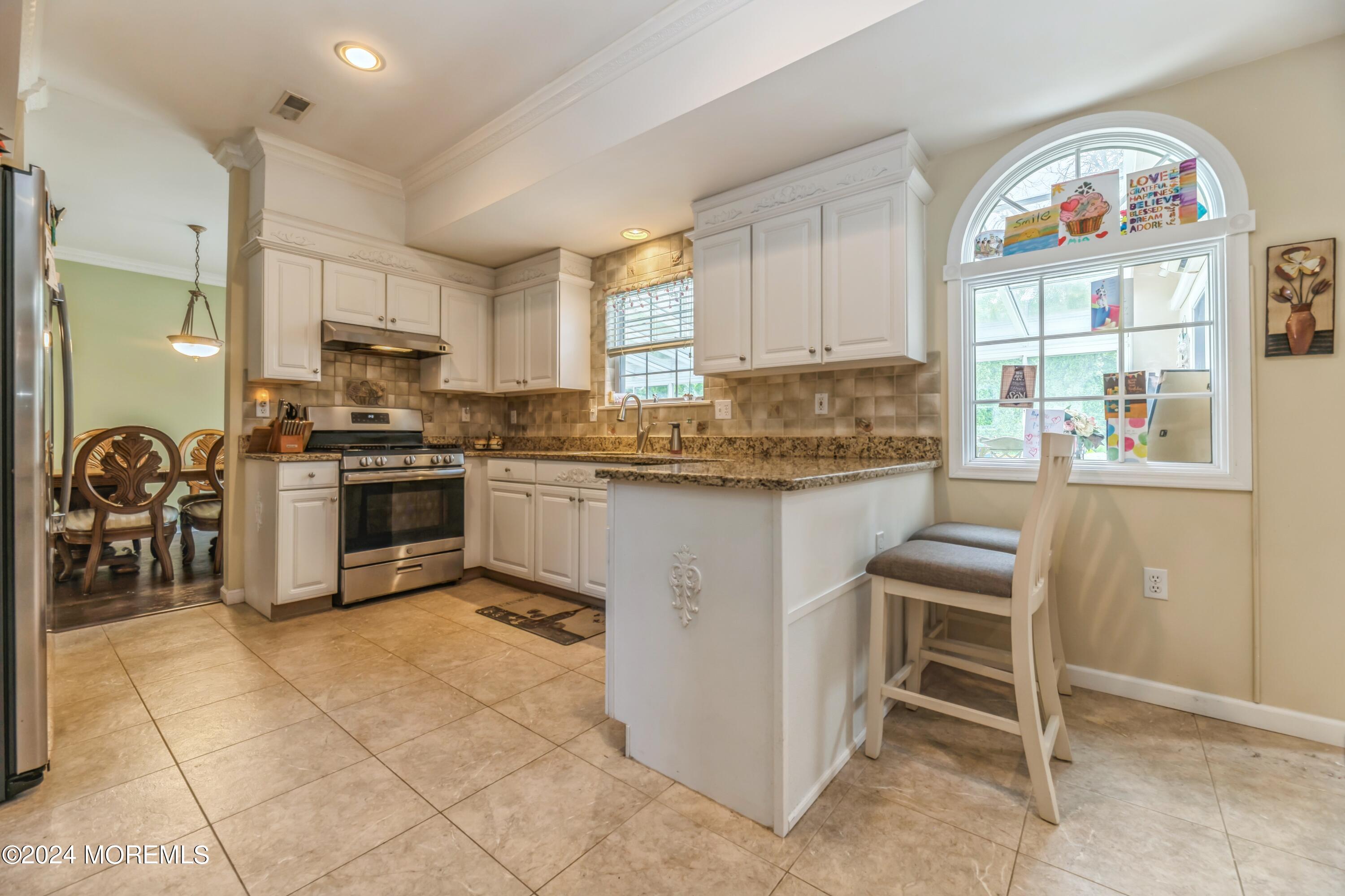 95 Nutmeg Road Aberdeen, NJ 07747 - Photo 7 of 21 a kitchen with stainless steel appliances granite countertop a stove a sink and a microwave