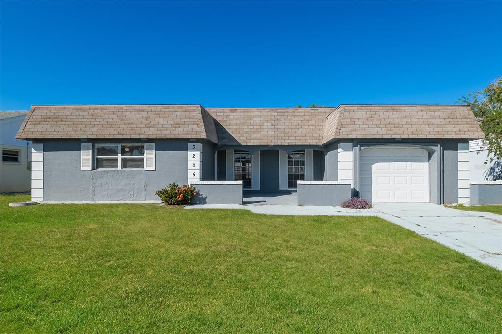 a view of a house with a patio and a yard