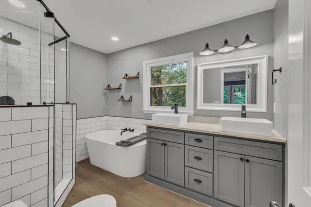 a bathroom with a tub a sink and mirror