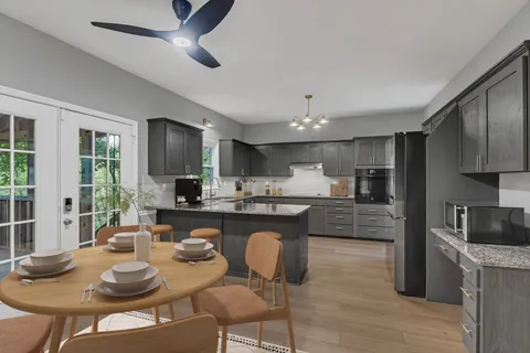 a kitchen with kitchen island granite countertop a sink and refrigerator