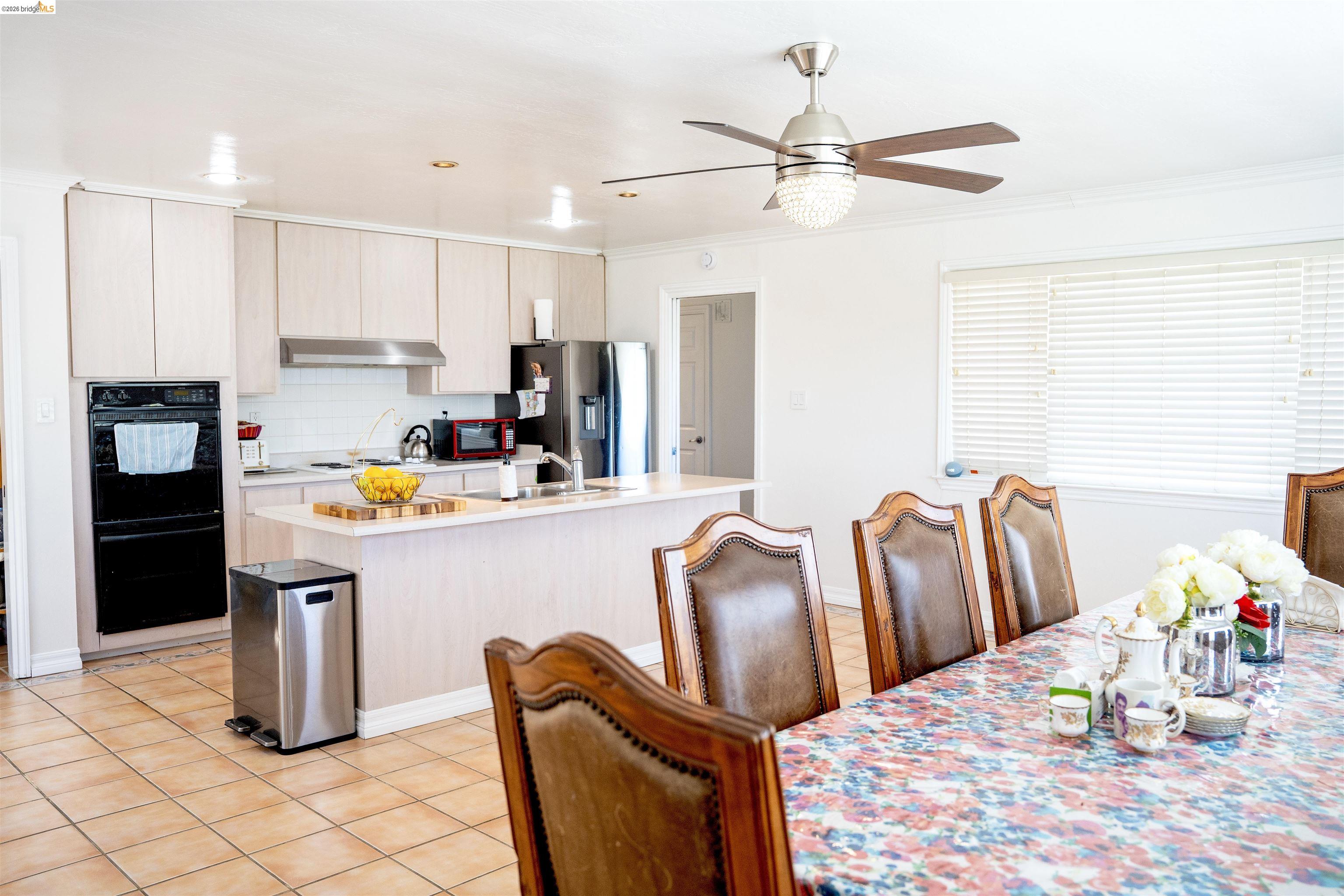 64 Washington Street Novato, CA 94947 - Photo 7 of 21 Spacious kitchen featuring light-toned cabinetry, stainless steel appliances, a center island with sink, and tile flooring