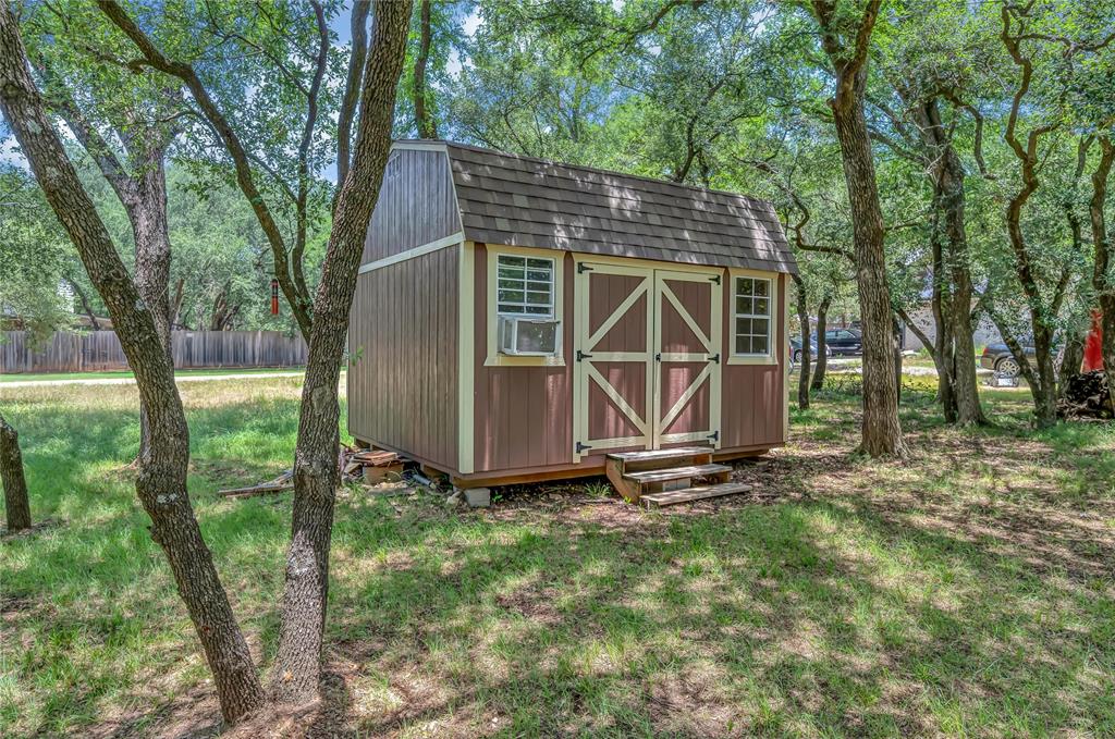 37 Bluebonnet Loop Morgan's Point Resort, TX 76513 - Photo 33 of 38 Freestanding shed featuring a brown and cream exterior, dual barn-style doors, multi-pane windows, and a shingled gambrel roof