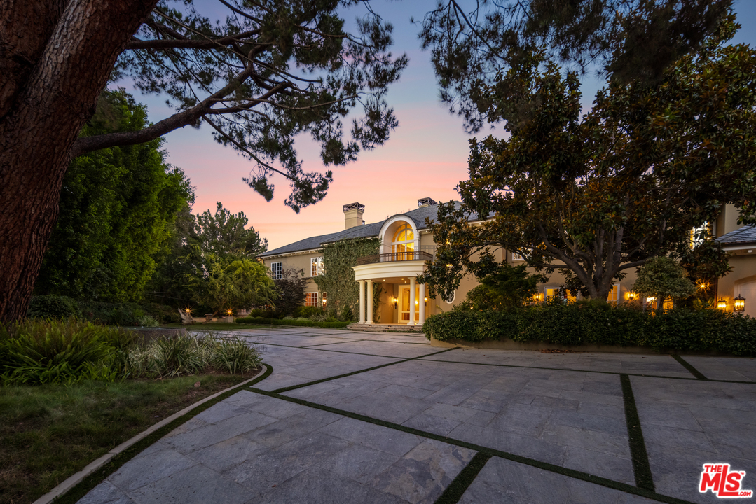 a front view of a house with a yard and trees