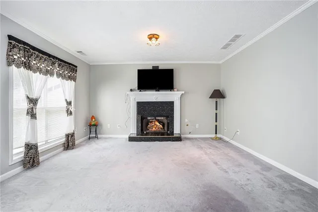 a view of an empty room with a fireplace and a window