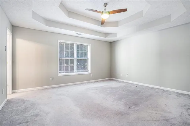 an empty room with a window and a fan