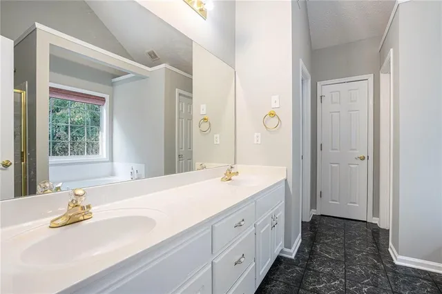 a spacious bathroom with a granite countertop sink and a mirror