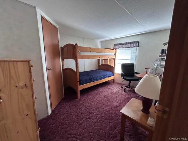 a bedroom with a bed and dresser next to a window