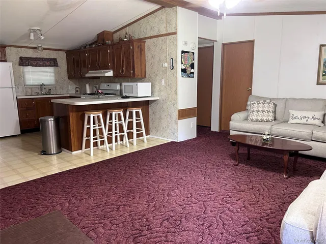 a kitchen with stainless steel appliances kitchen island granite countertop a refrigerator a stove a sink and a microwave