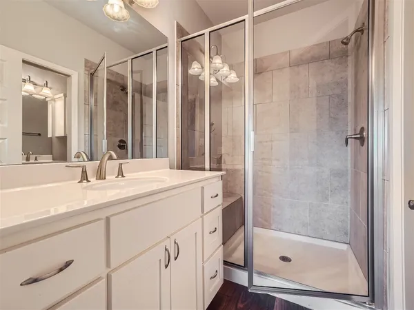 a bathroom with a shower sink and mirror