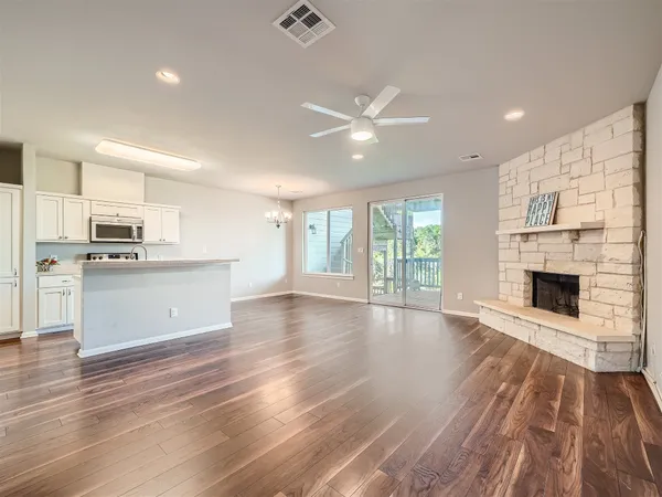 a view of a kitchen with wooden floor and a ceiling fan