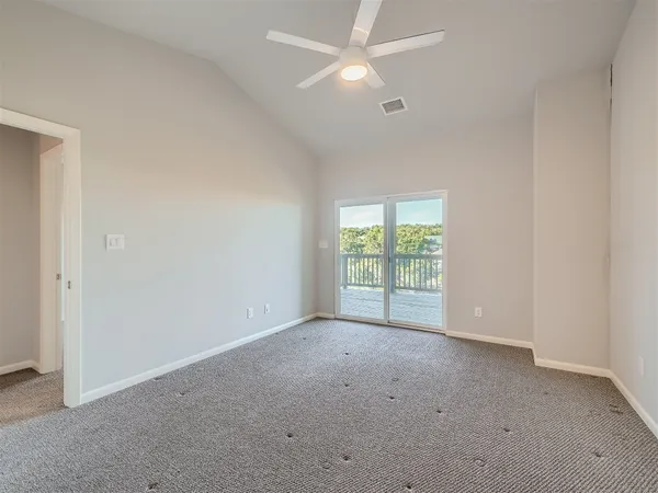an empty room with a fan & a window