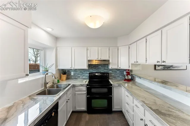 a kitchen with a sink stove top oven and cabinets