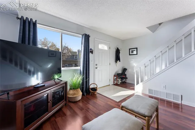 a living room with furniture fireplace and wooden floor