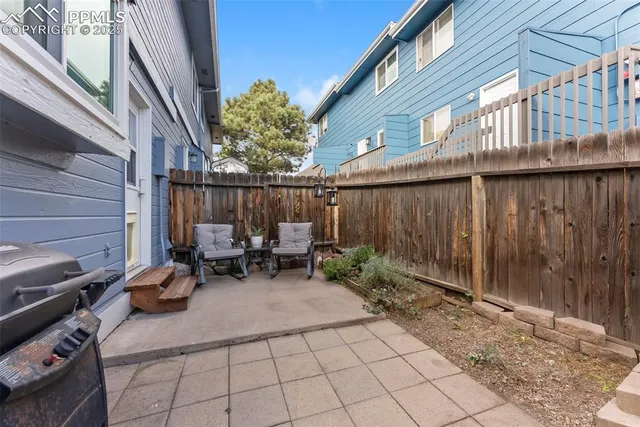 a view of backyard with a table and chairs and a barbeque
