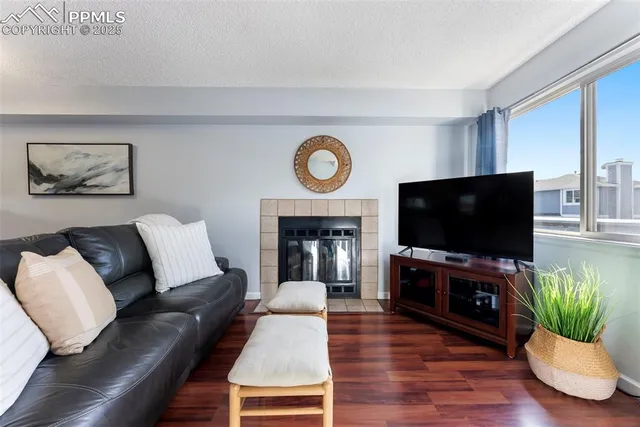 a living room with furniture a flat screen tv and a fireplace