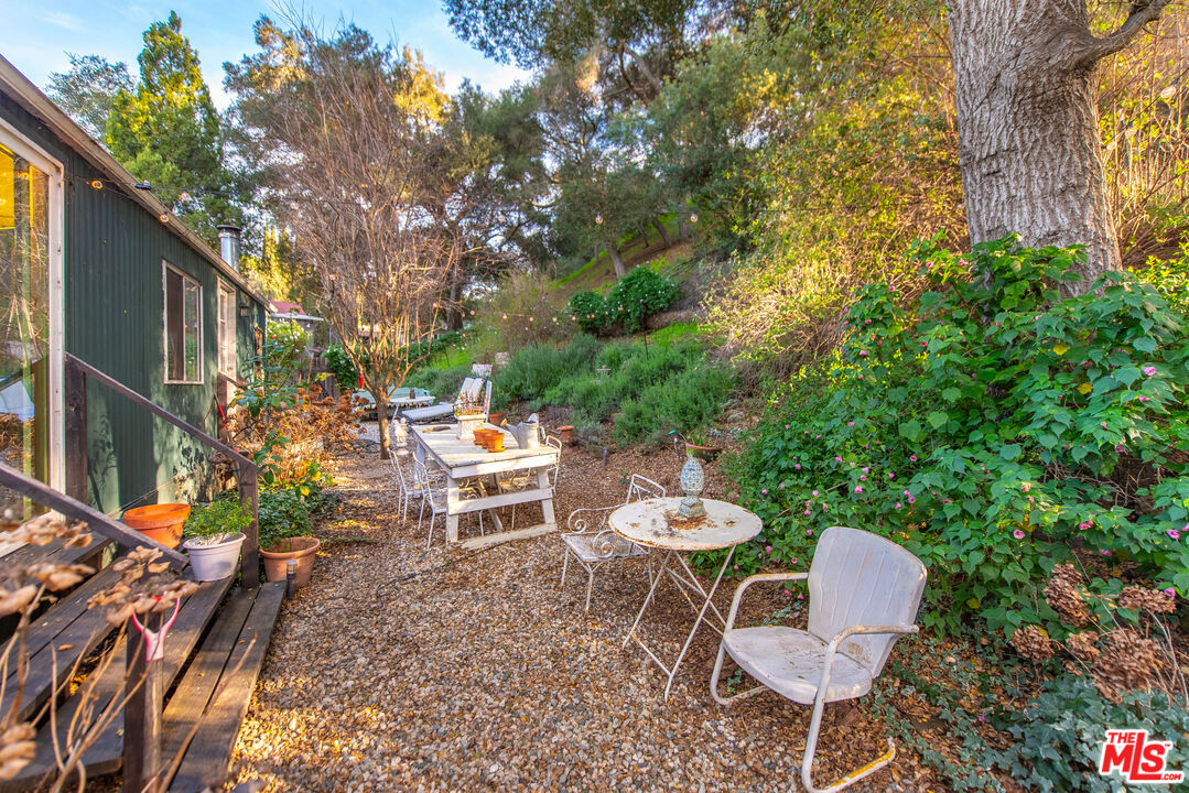 1667 Las Virgenes Canyon Road, Unit 5 Calabasas, CA 91302 - Photo 12 of 36 a backyard of a house with table and chairs