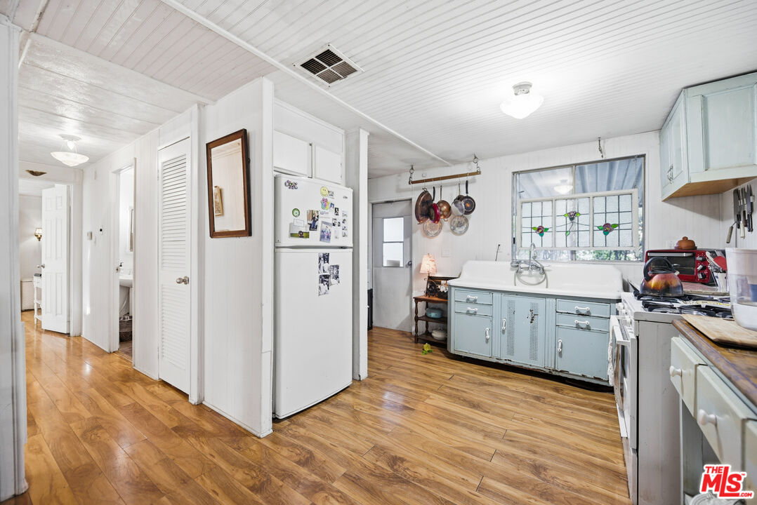 1667 Las Virgenes Canyon Road, Unit 5 Calabasas, CA 91302 - Photo 13 of 36 a kitchen with cabinets and wooden floor