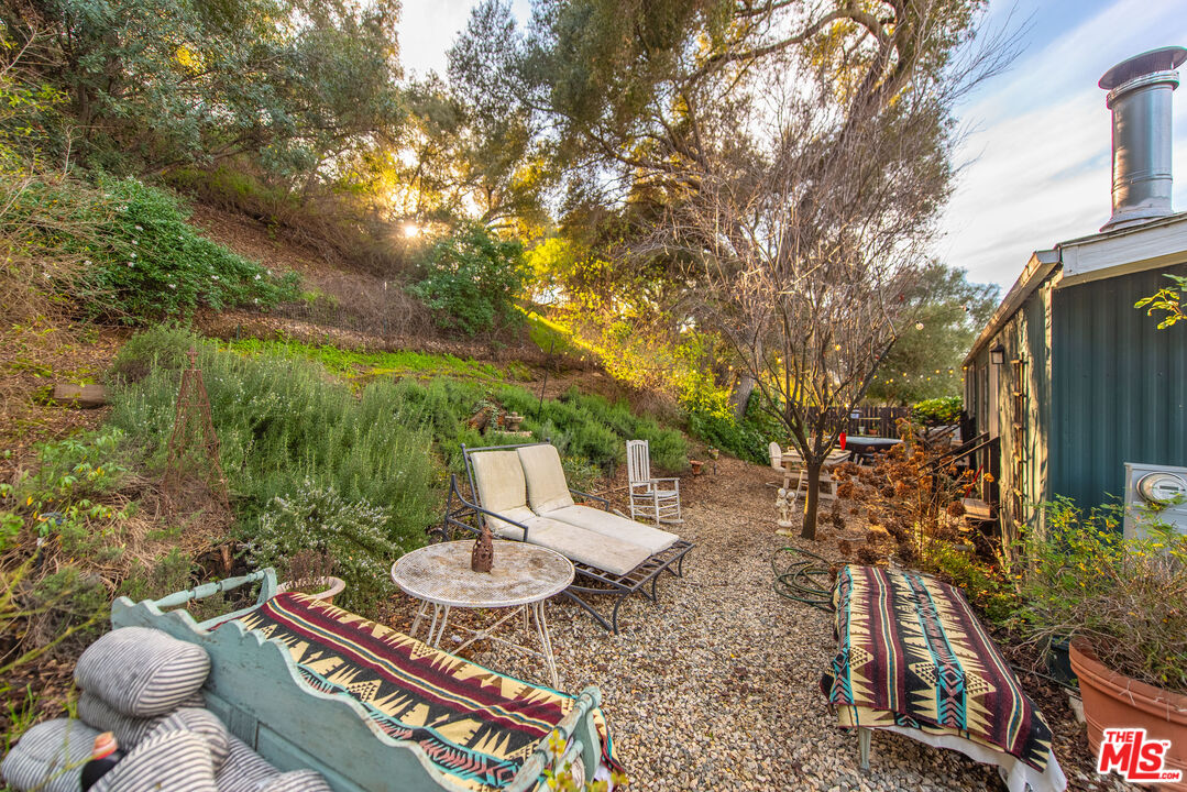 1667 Las Virgenes Canyon Road, Unit 5 Calabasas, CA 91302 - Photo 2 of 36 a view of a chairs and table in the backyard