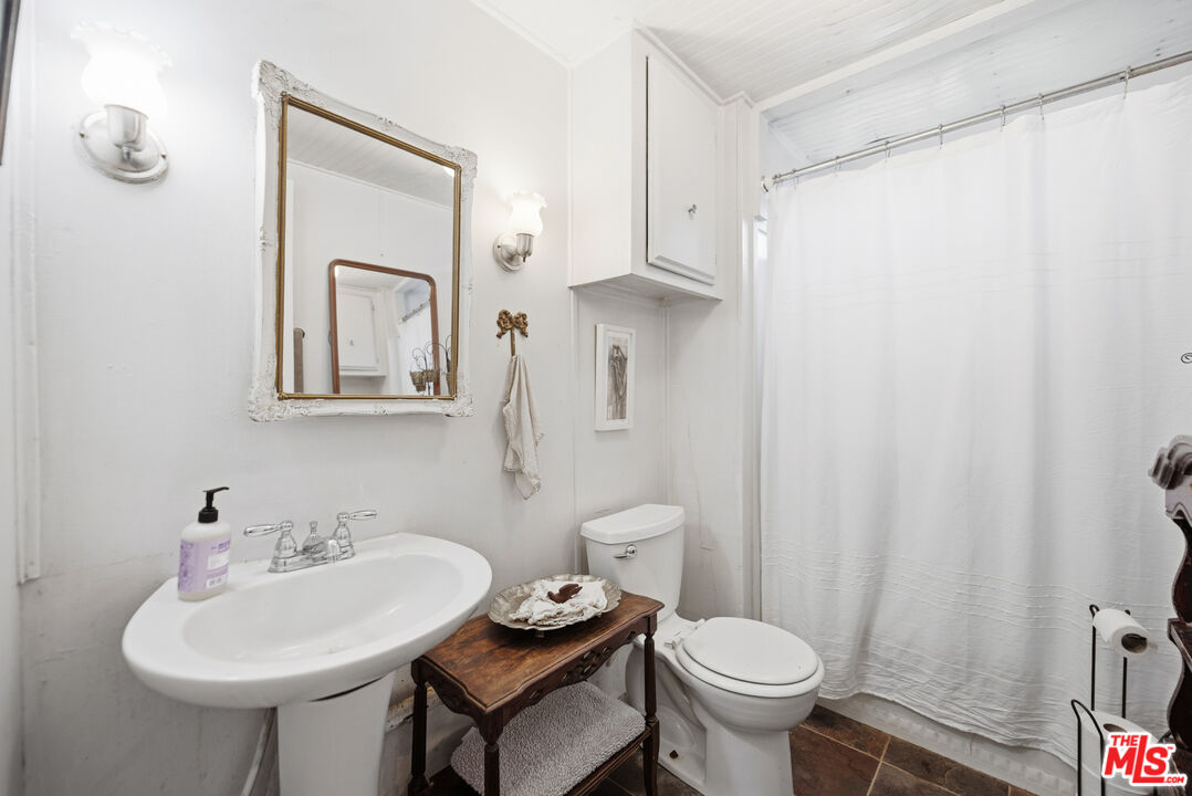 1667 Las Virgenes Canyon Road, Unit 5 Calabasas, CA 91302 - Photo 21 of 36 a bathroom with a toilet sink and mirror