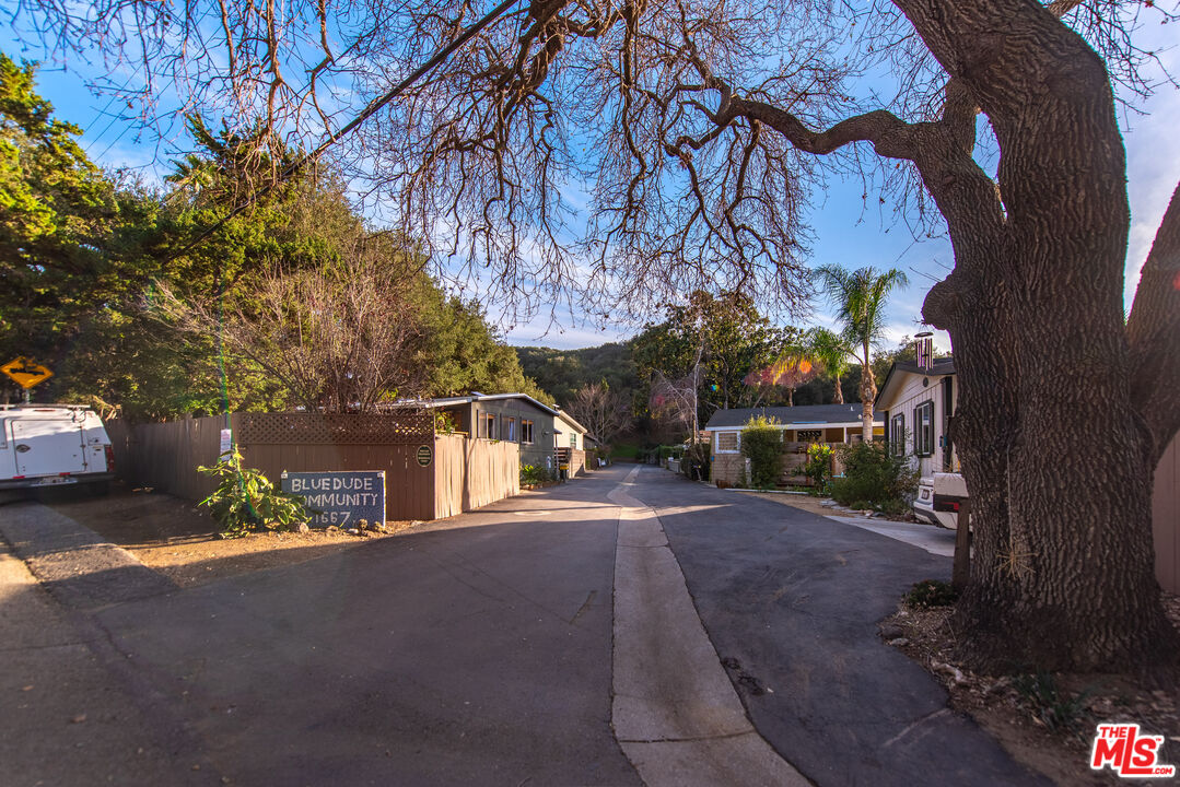 1667 Las Virgenes Canyon Road, Unit 5 Calabasas, CA 91302 - Photo 35 of 36 a front view of a house with a yard and tree s