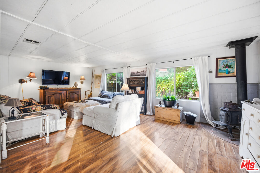 1667 Las Virgenes Canyon Road, Unit 5 Calabasas, CA 91302 - Photo 6 of 36 a living room with furniture large window and flat screen tv