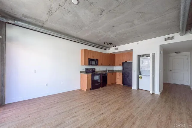 a large kitchen with a wooden floor and a refrigerator
