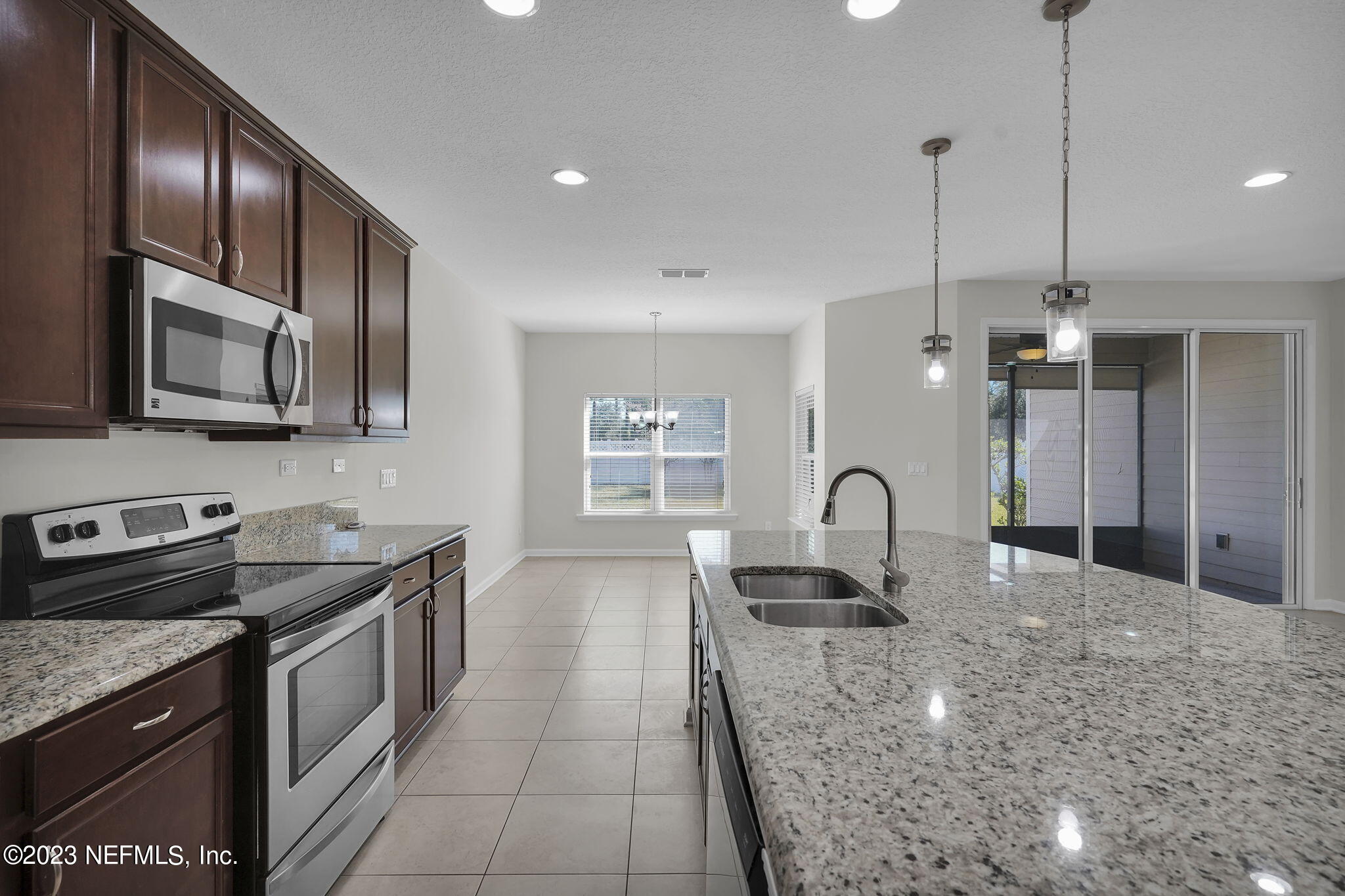 3513 Butternut Way Orange Park, FL 32065 - Photo 13 of 38 a kitchen with kitchen island granite countertop a stove a sink a oven with a dining table and chairs