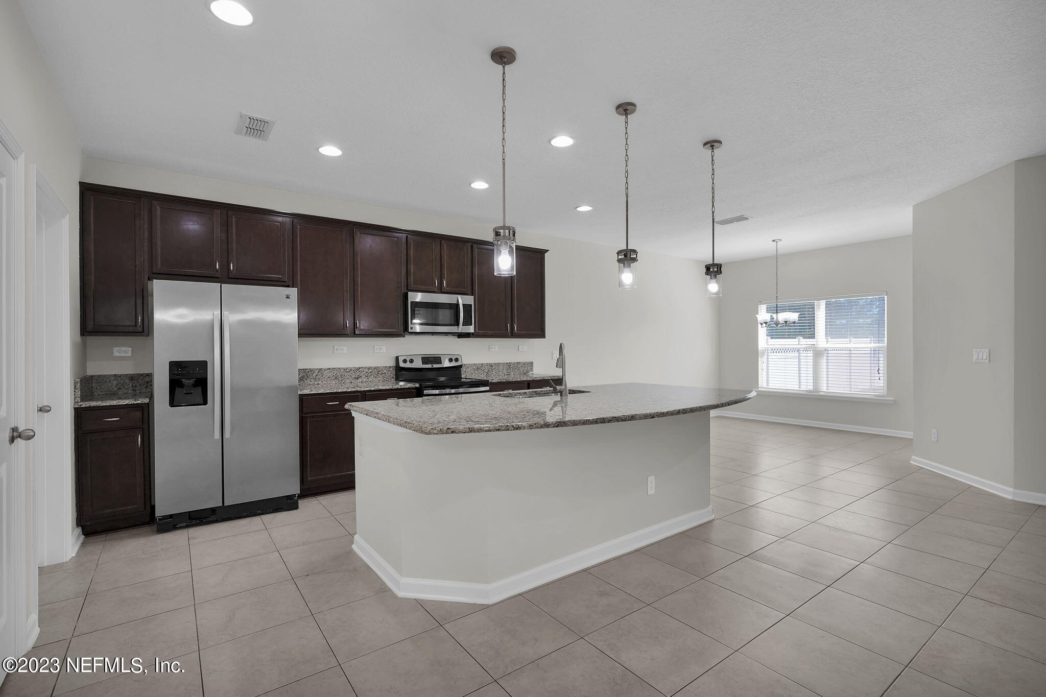 3513 Butternut Way Orange Park, FL 32065 - Photo 10 of 38 a large kitchen with stainless steel appliances kitchen island granite countertop a refrigerator a sink a stove and oven