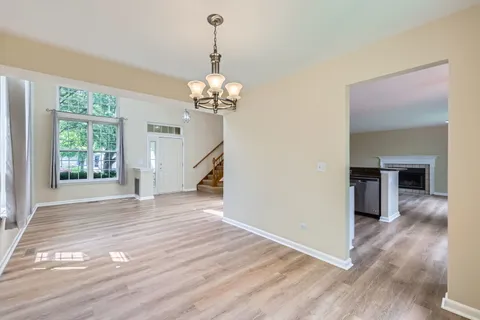 a view of empty room with wooden floor fireplace and windows