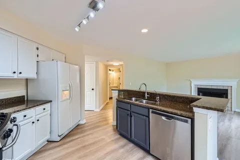 a kitchen with granite countertop a sink stove and refrigerator