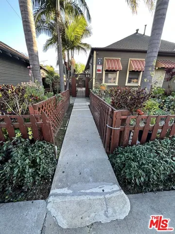 a view of a house with a yard and potted plants
