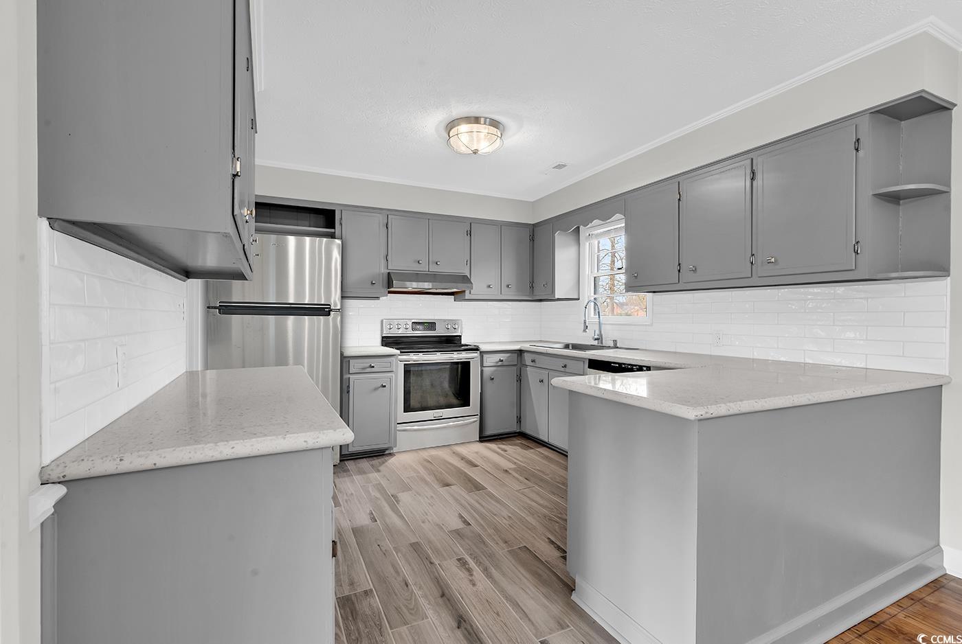 4320 Stevens Street Loris, SC 29569 - Photo 10 of 33 Kitchen featuring a peninsula, gray cabinets, unde