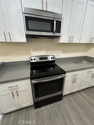 an empty room with wooden floor a ceiling fan and windows